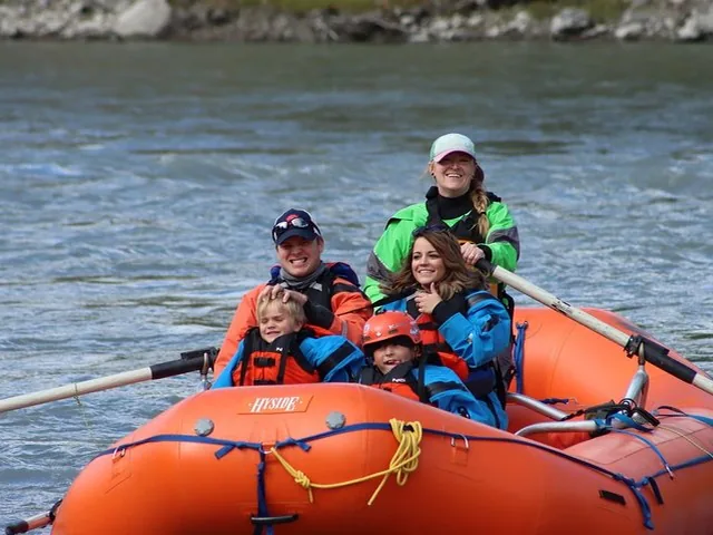 a family enjoying a guided raft trip on a river